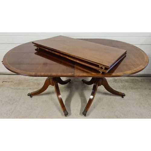 1465 - A large reproduction dark wood, oval shaped, extending dining table with brass inlaid detail. Turned... 