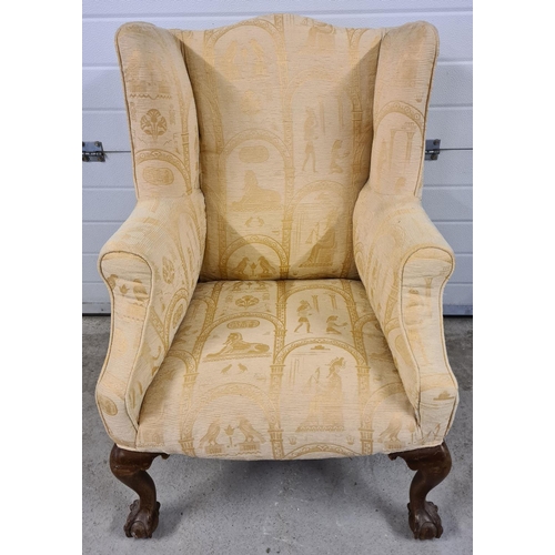 1469 - A vintage wooden framed wing back arm chair with ball & claw carved front feet. Reupholstered in a c... 