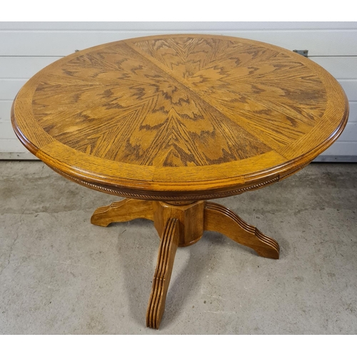 1471 - A vintage circular light wood dining table with central turned pedestal base. 4 feet with channelled... 