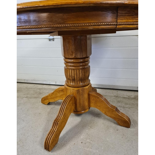 1471 - A vintage circular light wood dining table with central turned pedestal base. 4 feet with channelled... 