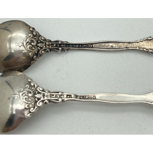 1196 - 2 vintage decorative silver salt spoons with scroll and floral detail. Both Marked Sterling to back.... 