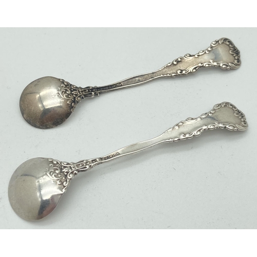 1196 - 2 vintage decorative silver salt spoons with scroll and floral detail. Both Marked Sterling to back.... 