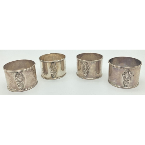 1199 - A set of 4 Thai silver napkin rings with Thai deity decoration to front. Each napkin marked 