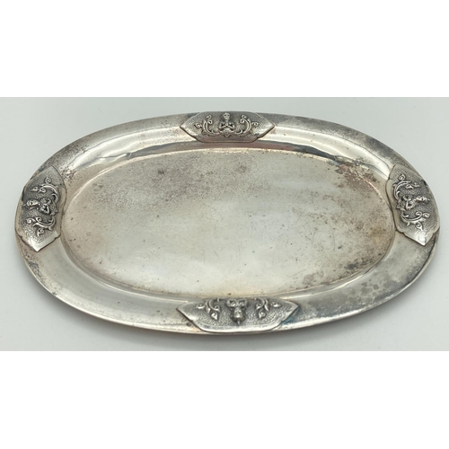 1200 - A Sterling silver oval shaped pin tray with oriental deity decoration to four sides. Back marked 