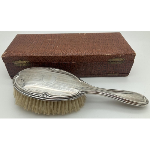 1203 - An Art Deco silver backed hair brush with engine turned decoration and central empty cartouche in or... 