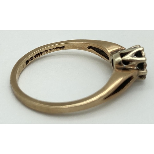 1071 - A 9ct yellow gold illusion set diamond solitaire ring with open shoulders. Fully hallmarked inside b... 