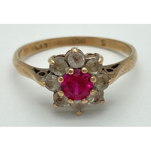 1072 - A 9ct gold flower cluster ring set with central pink ruby surrounded by 8 colourless spinel stones. ... 