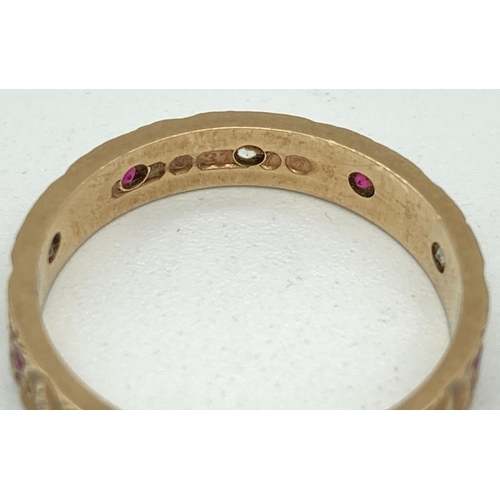 1075 - A fully hallmarked vintage 9ct gold full eternity ring set with rubies and clear stones. With engrav... 