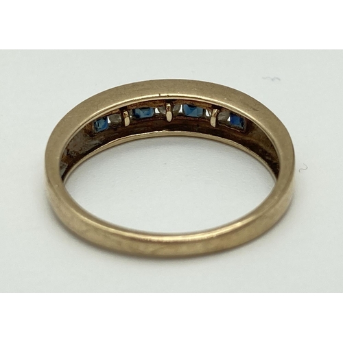 1076 - A 9ct yellow gold ring with channel set square cut sapphires and round cut cubic zirconia's. Fully h... 