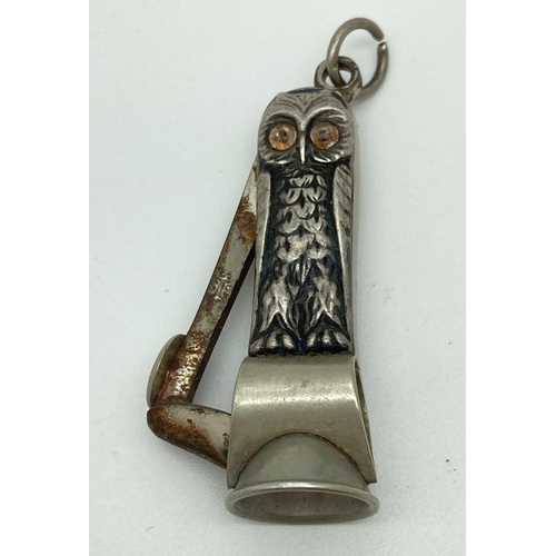 1207 - An antique white metal novelty cigar cutter in the form of an owl. With glass eyes and hanging bale.... 