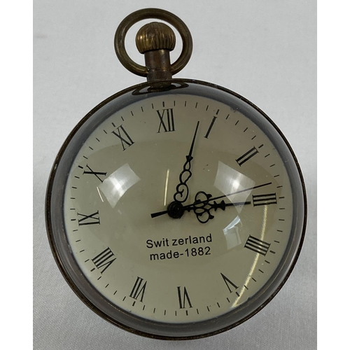 1254 - A top winding glass ball watch, bound in brass with roman numeral markers. Approx. 6cm diameter. In ... 