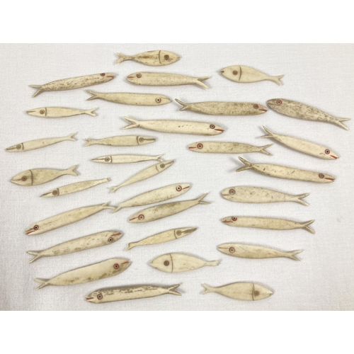 1382 - A collection of 30 antique bone gaming counters in the shape of fish. In varying sizes. Longest appr... 