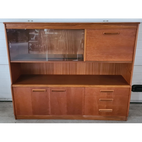 1486 - A mid century teak low display unit with glass sliding doors, cupboards and 3 drawers. With integral... 