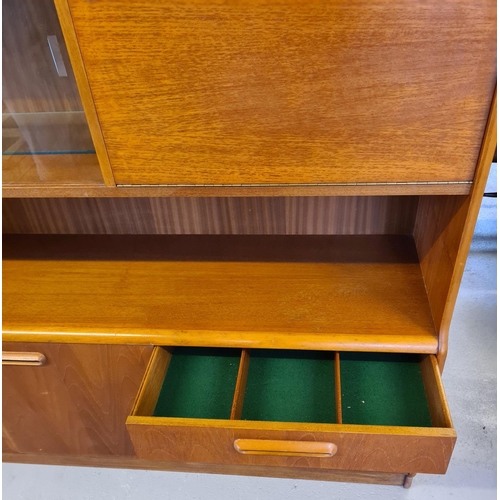 1486 - A mid century teak low display unit with glass sliding doors, cupboards and 3 drawers. With integral... 