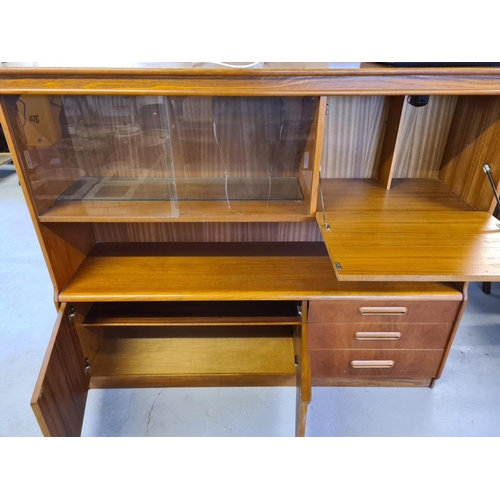 1486 - A mid century teak low display unit with glass sliding doors, cupboards and 3 drawers. With integral... 