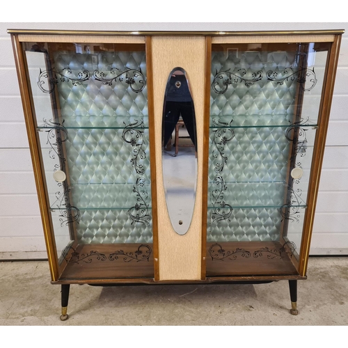 1489 - A mid century double door glass display cabinet with central mirrored panel. Pale green quilted effe... 