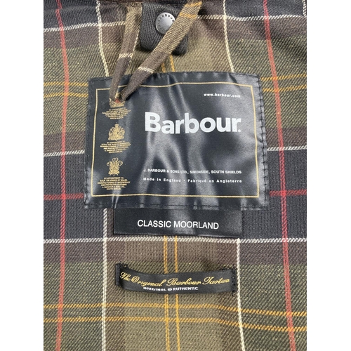 66 - A men's A821 classic Moorland wax jacket by Barbour. Double fastener zip to front with press stud de... 