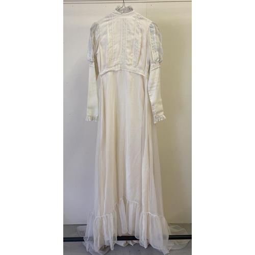 299 - A cream chiffon overlay 1970's wedding dress with small train. With lace detail to sleeves, yoke, hi... 