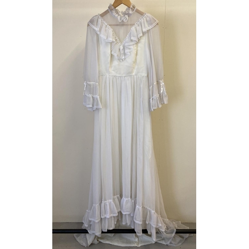 306 - A vintage 1970's frill sleeved high necked wedding dress with small train. With V shaped frill detai... 