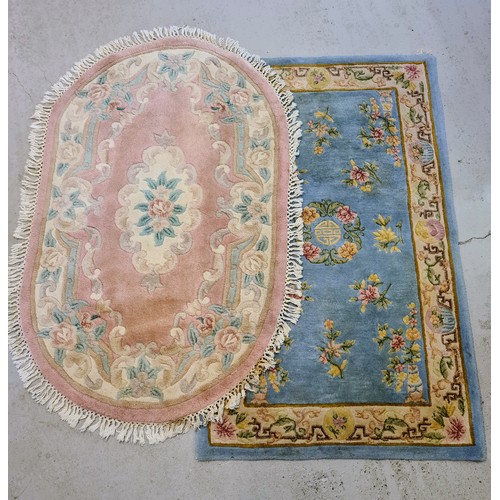 1438 - 2 vintage Chinese design rugs. A rectangular pale blue ground rug and an oval shaped pink ground rug... 