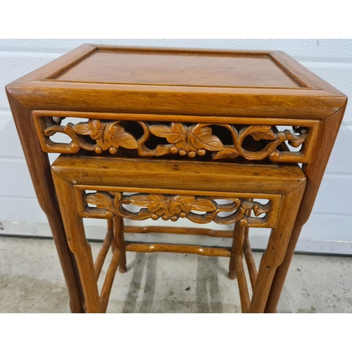 1396 - 2 Oriental nesting tables with shaped legs and carved pierced work detail of grape vine design. Larg... 