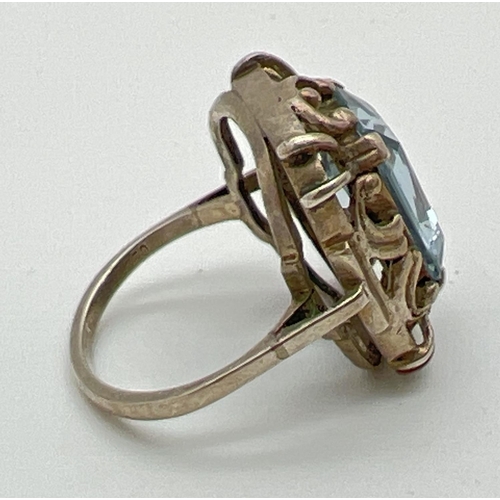 1071 - A continental silver cocktail ring set with an emerald cut pale blue spinel stone. Pierced work moun... 