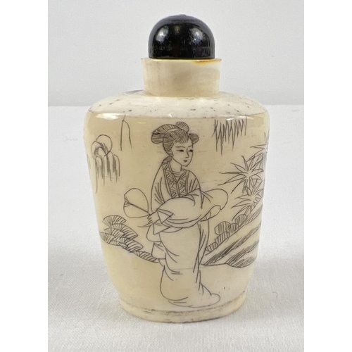 1276 - A small oriental style scent bottle in cream and black depicting an oriental lady in a garden scene.... 