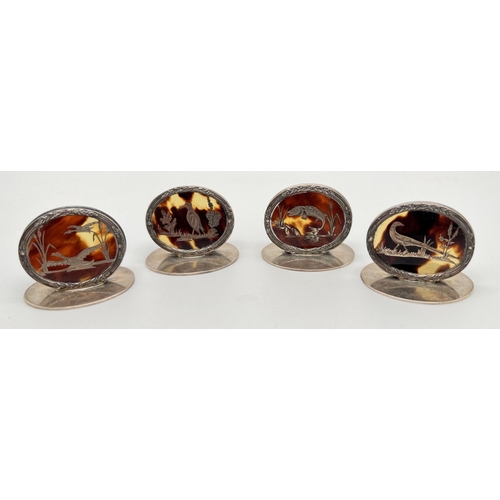 1156 - A set of 4 early 20th century silver and tortoiseshell menu holders. 3 depicting game birds and 1 a ...