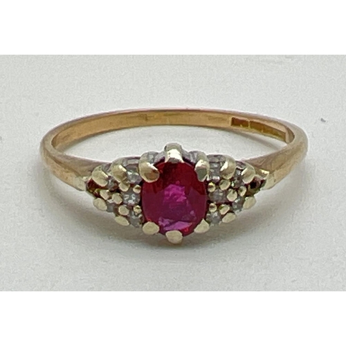 1036 - A vintage 9ct gold ruby and diamond dress ring. Central oval cut ruby with 5 small diamonds to eithe... 