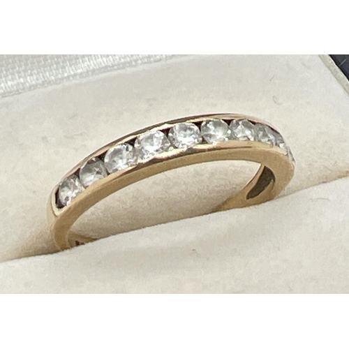 1056 - A 9ct yellow gold half eternity ring with channel set round cut clear stones. Fully hallmarked insid... 