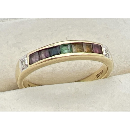 1001 - A 14ct gold ring set with 7 square cut channel set rainbow gemstones and flanked by diamonds. Gemsto... 