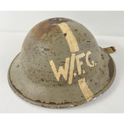 11 - A British WWII MkII Home Front steel helmet, stamped 1941. Painted grey with longitudinal white stri... 