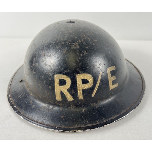 15 - A WWII British Home Front MkII steel helmet, painted black with letters RP/E. For Repair Party/Elect... 
