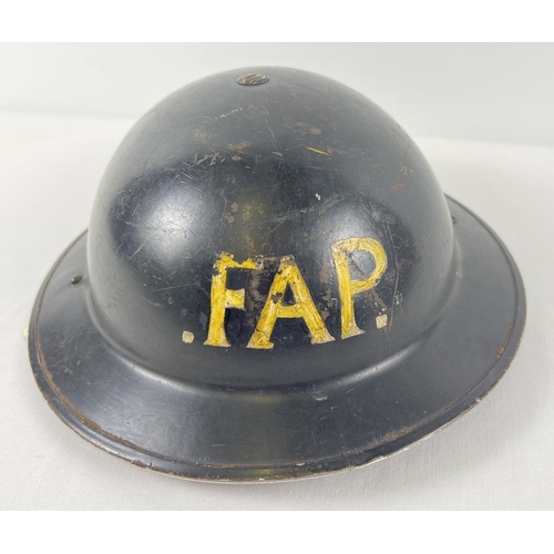 17 - A WWII British Home Front MkII steel helmet painted black and labelled in yellow 'FAP' to front crow... 