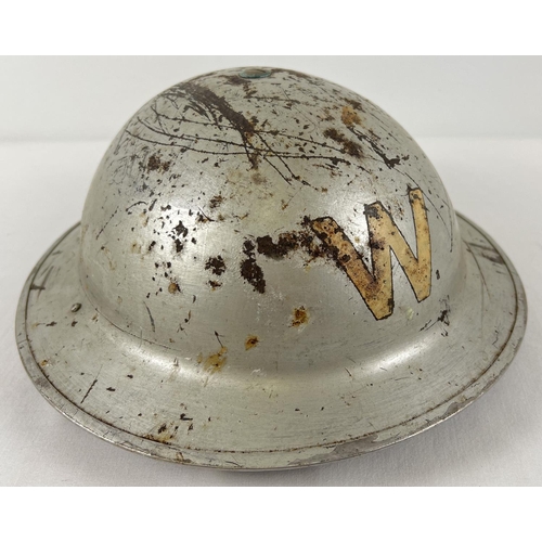 43 - A WWII British Home Front steel helmet with early oval pad, painted silver over khaki. Labelled W fo... 