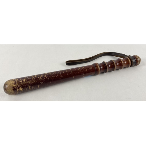 59 - A vintage wooden truncheon with ribbed handle and leather thong. Approx. 40cm long.