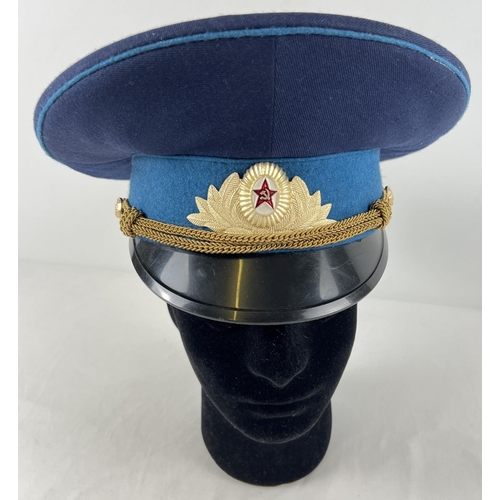 179 - A vintage Soviet peaked cap with bullion rope detail, metal cap badge and buttons.