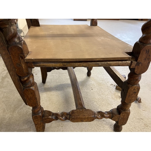 1300 - A late 17th century walnut high back armchair with barley twist columns. Carved scroll and cherub de... 