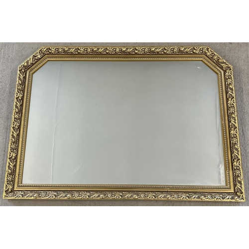 1321 - A large gilt framed wall hanging over mantle mirror with foliate design. Approx. 72 x 103cm.