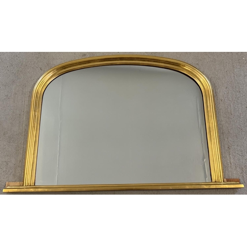 1322 - A large curved top gilt framed over mantel mirror with plinth base. Approx. 77 x 118cm.