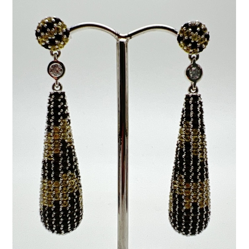 1063 - A pair of silver drop style earrings set with a large number of small round cut smoked quartz stones... 