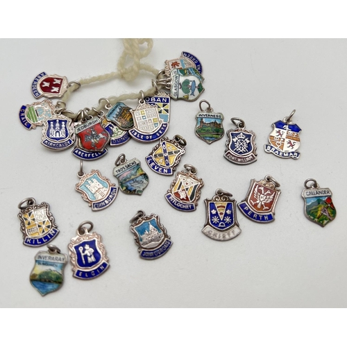 1064 - A collection of 28 vintage silver and enamel shield shaped charms/pendants of various places in Scot... 