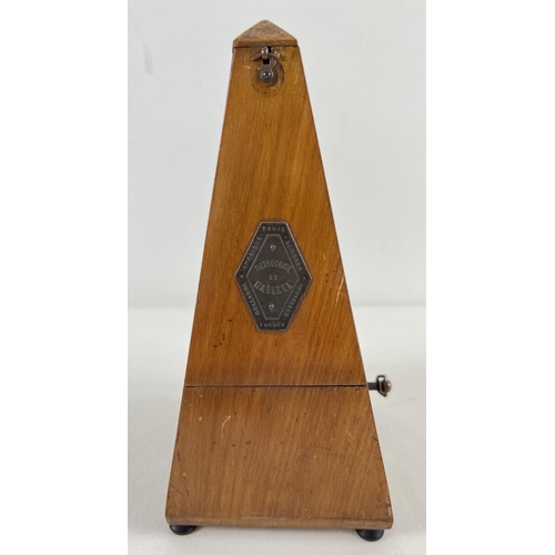 1265 - A vintage wooden cased Maelzel metronome raised on tripod wooden feet and with brass plaque to door.... 