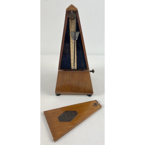 1265 - A vintage wooden cased Maelzel metronome raised on tripod wooden feet and with brass plaque to door.... 