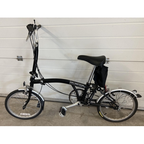 1268 - A Brompton L3 folding bike in black, with original purchasers receipt. Complete with instruction man... 