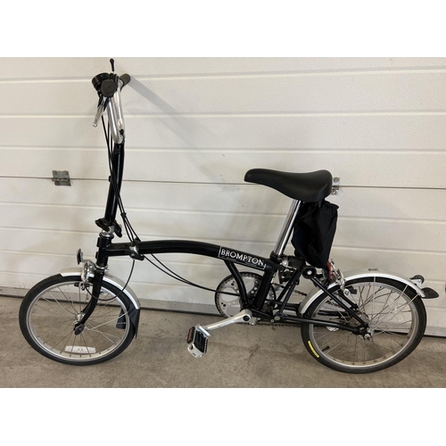 1268 - A Brompton L3 folding bike in black, with original purchasers receipt. Complete with instruction man... 