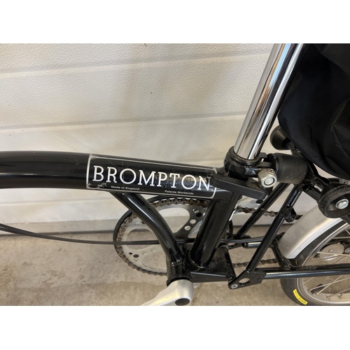 1268 - A Brompton L3 folding bike in black, with original purchasers receipt. Complete with instruction man... 