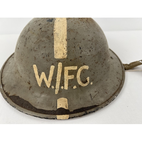 1142 - A British WWII MkII Home Front steel helmet, stamped 1941. Painted grey with longitudinal white stri... 