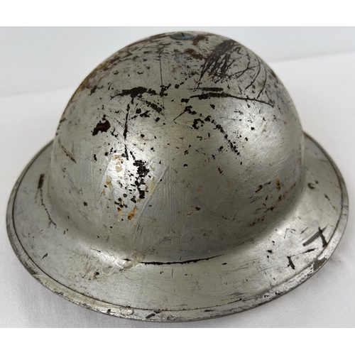 1145 - A WWII British Home Front steel helmet with early oval pad, painted silver over khaki. Labelled W fo... 