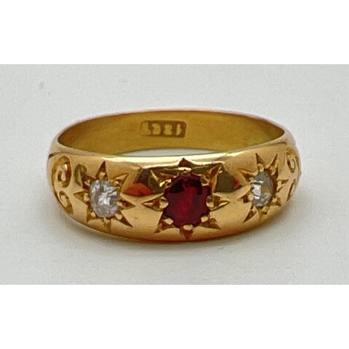 1012 - An 18ct gold gypsy style ring set with a central garnet and 2 diamonds. Stones set with claws and in... 